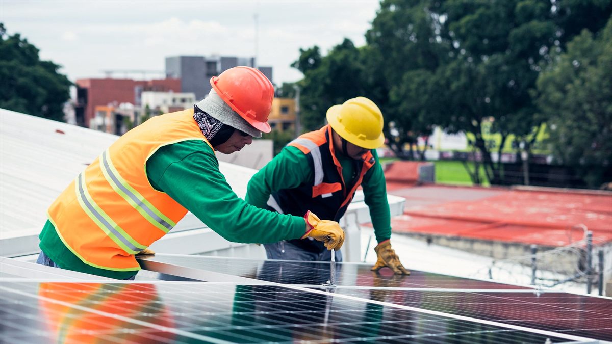 Técnicos montando paneles solares sobre una cubierta