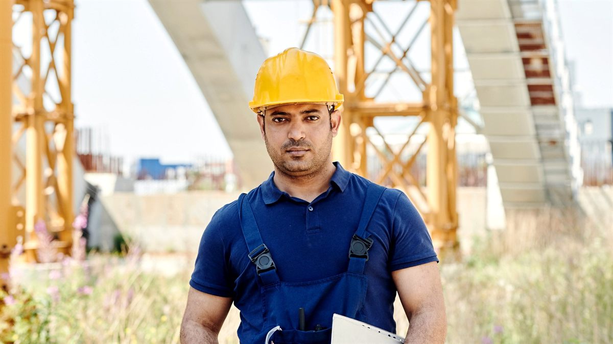 Supervisor de obra con casco y carpeta en una construcción